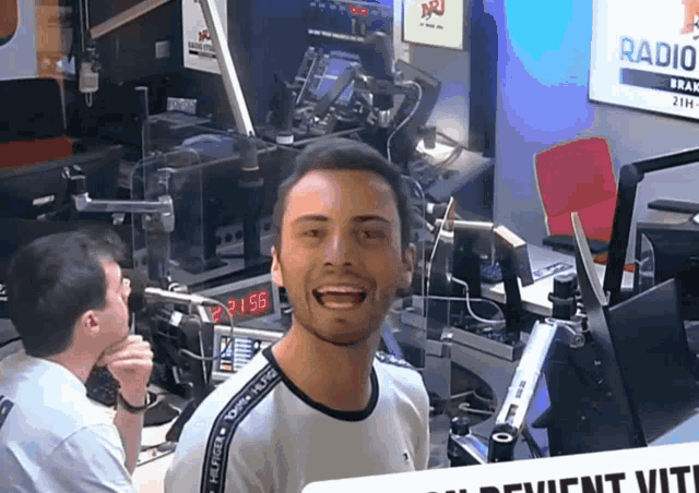 a man in a radio station with a sign that says " radio " on it