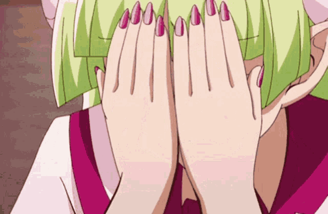 a girl with pink nails is covering her face with her hands .
