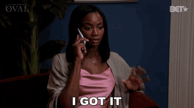 a woman sitting in a chair talking on a cell phone and saying " i got it "