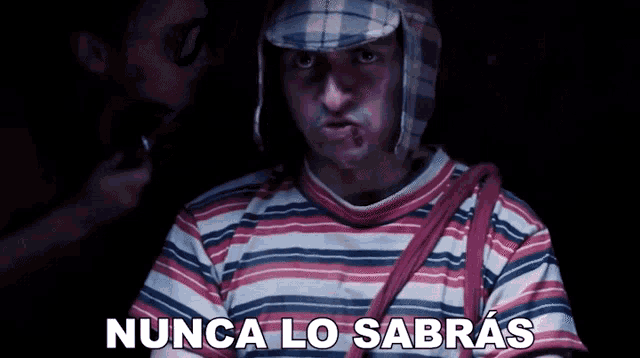 a man wearing a hat and striped shirt says nunca lo sabras