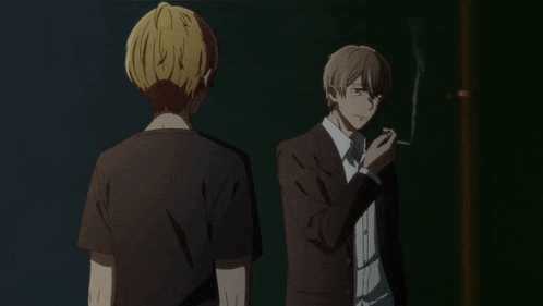 a man in a suit smoking a cigarette while another man looks on