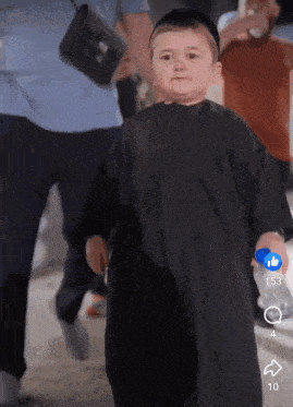 a little boy in a black robe is holding a blue bottle with the number 153 next to him