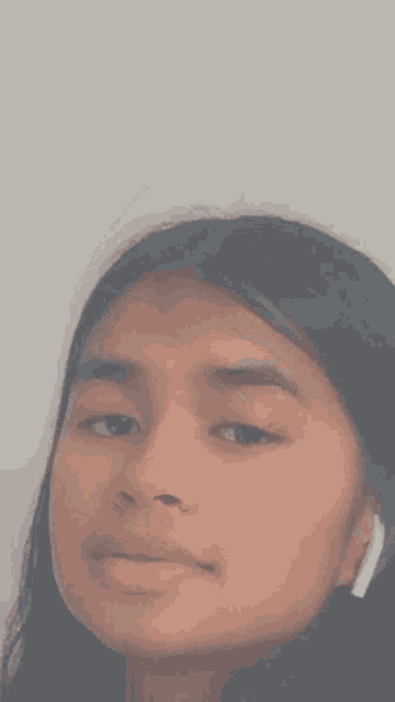 a close up of a girl 's face against a white wall