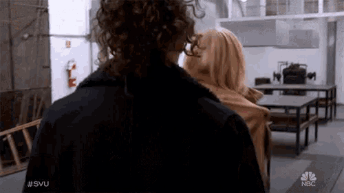 two people walking in a room with a nbc logo on the bottom right