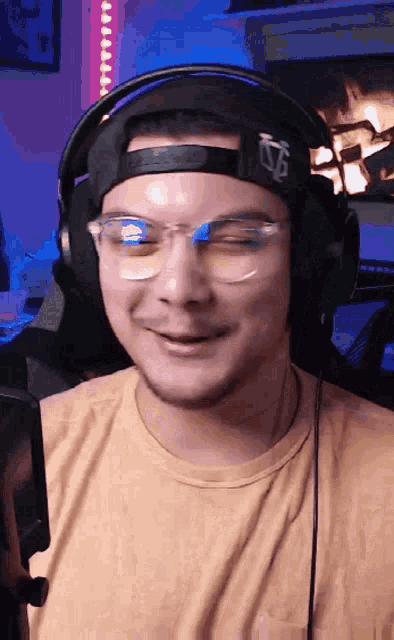 a man wearing headphones and glasses is smiling and winking