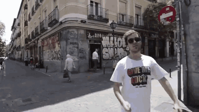 a man in a white shirt that says give me cock