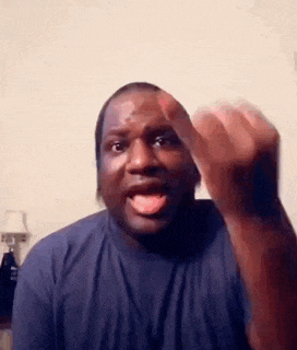 a man in a blue shirt is making a funny face while giving the middle finger .