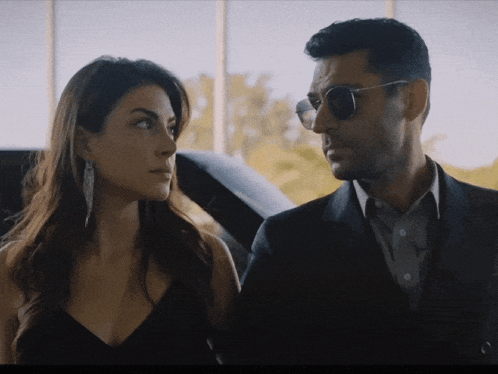 a man and a woman are standing next to each other and looking at each other