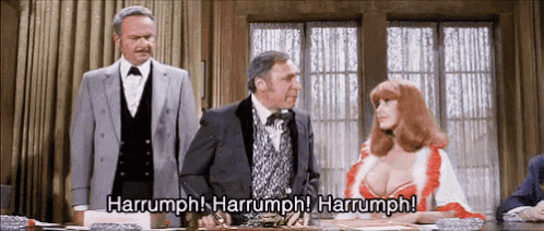 a man in a suit and tie stands next to a woman in a red dress and says harrumph harrumph harrumph