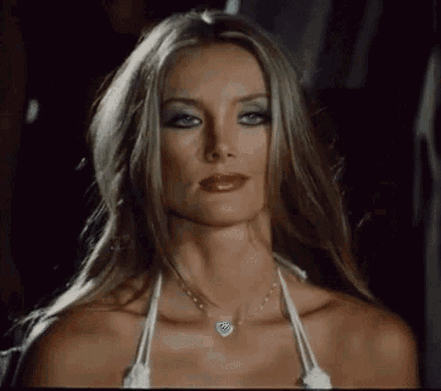 the woman is wearing a white bikini top and a necklace .