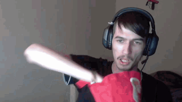 a man wearing headphones and holding a red shirt