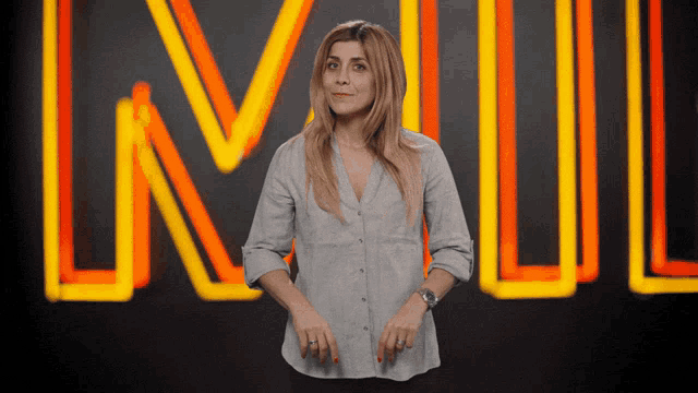a woman stands in front of a neon sign that says lnl