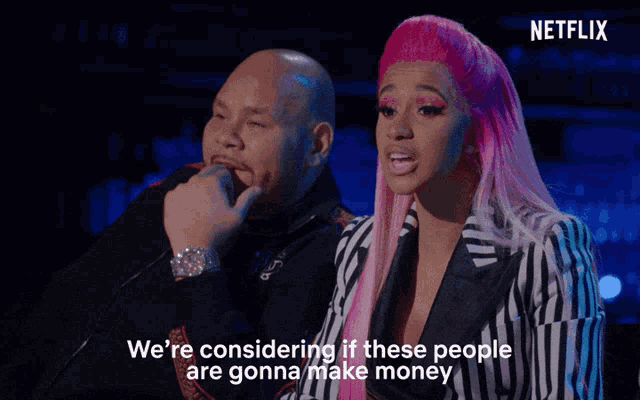 a man and a woman are sitting next to each other and the woman is wearing pink hair and the man is wearing a watch