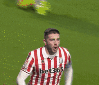 a soccer player wearing a red and white striped jersey with the number 23 on it
