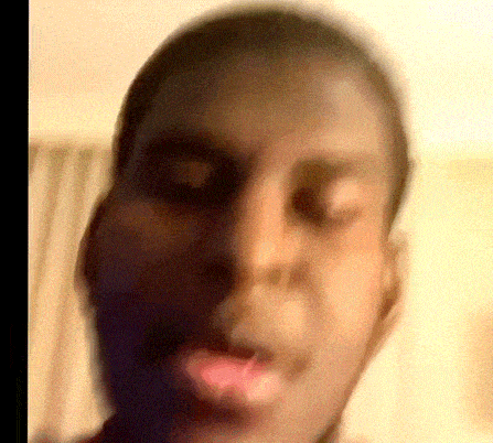 a close up of a man 's face with his mouth open and a blurred background .