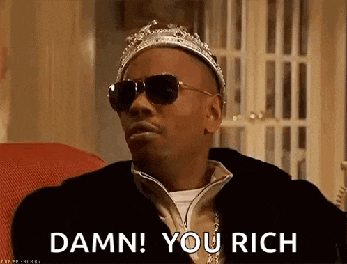 a man wearing a crown and sunglasses is sitting on a couch and saying `` damn you rich '' .