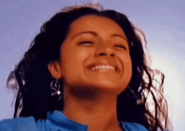 a close up of a woman 's face with her eyes closed smiling