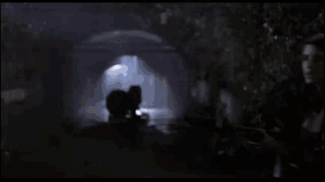 a woman is holding a gun in her hand and it is being fired at someone .