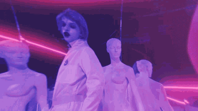a woman in a white jacket is standing in front of a group of mannequins