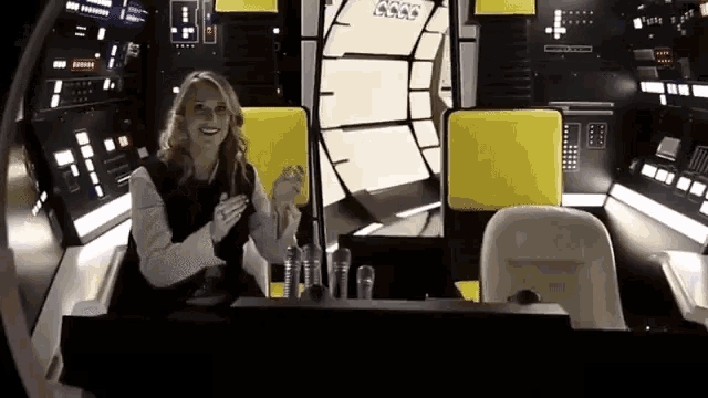 a woman is sitting in a spaceship with a sign that says axxx