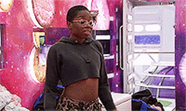 a woman in a crop top and leopard print shorts is standing in a room