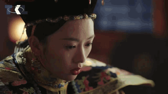 a woman in a traditional costume with foreign writing on the bottom right
