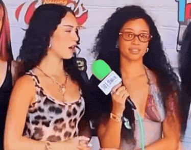 a woman is holding a green microphone that says hot only