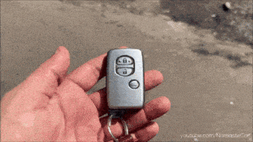a person is holding a silver toyota car key
