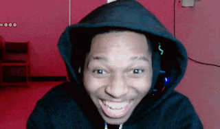 a man wearing a black hoodie with the letter s on it is smiling