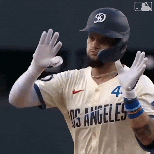 a baseball player wearing a los angeles uniform is waving his hands