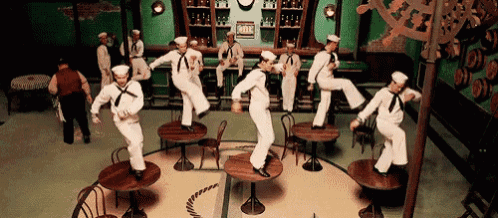 a group of sailors are jumping on tables in a room with a sign that says ' mix '