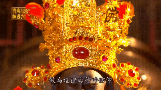 a close up of a gold crown with red stones