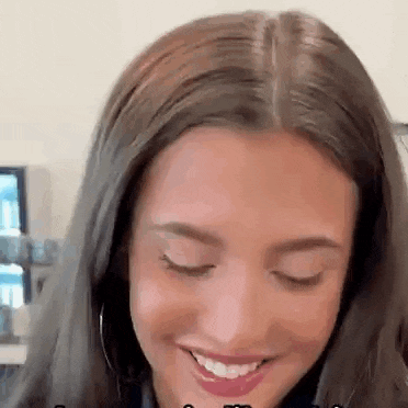 a close up of a woman 's face with her eyes closed and a smile on her face .