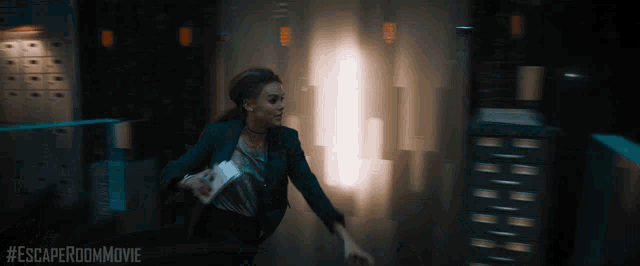 a woman in a suit is running through a dark room with the hashtag #escaperoommovie on the bottom