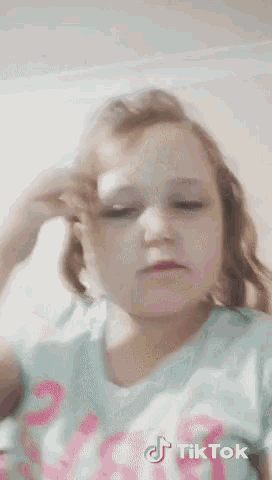 a little girl is wearing a shirt that says tiktok on it