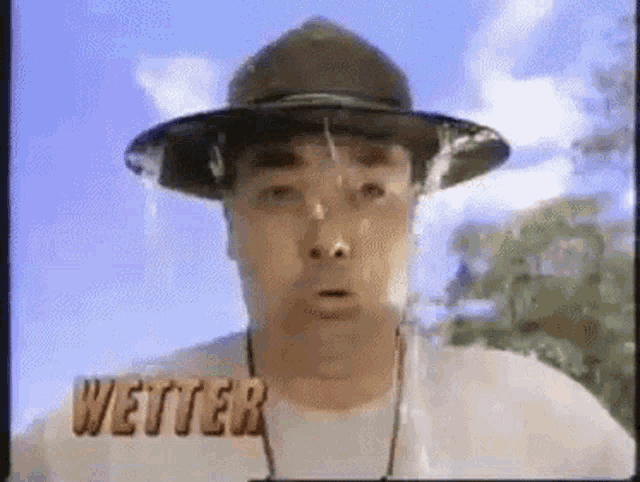 a man wearing a hat and a shirt with the word wetter written on it