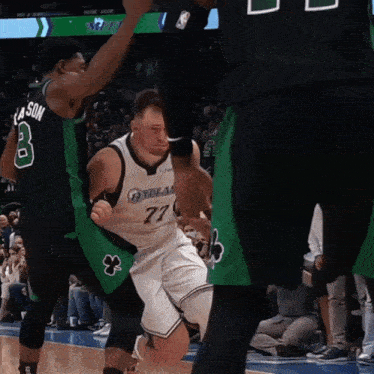 a basketball player wearing a dallas jersey is being chased by another player
