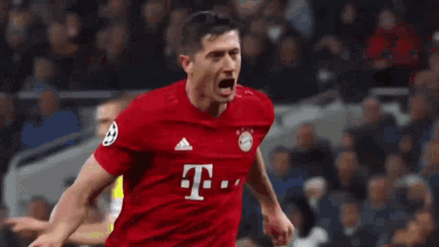 a soccer player wearing a red adidas jersey celebrates