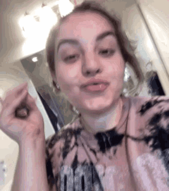 a young woman is taking a selfie in front of a mirror .