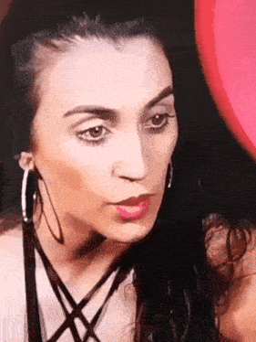 a close up of a woman wearing hoop earrings and a necklace
