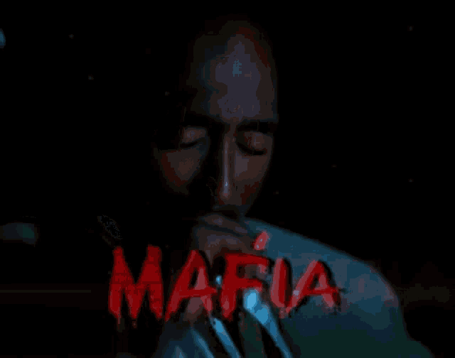 a man in a suit and tie is smoking a cigarette in front of the word mafia