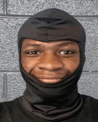 a man wearing a black mask looks at the camera