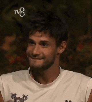 a man wearing a white sleeveless shirt is smiling .
