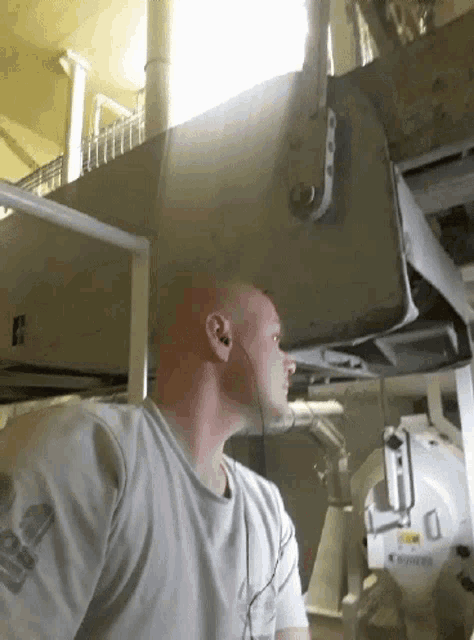 a man wearing headphones is standing in front of a machine that says power