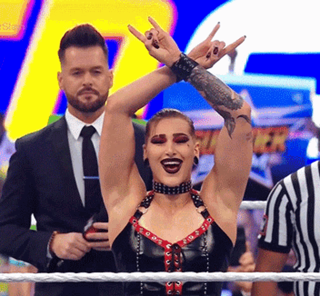 a woman in a wrestling ring making a rock sign