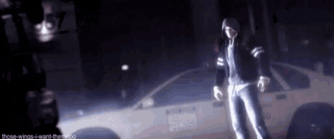 a man in a hooded jacket is standing in front of a white police car