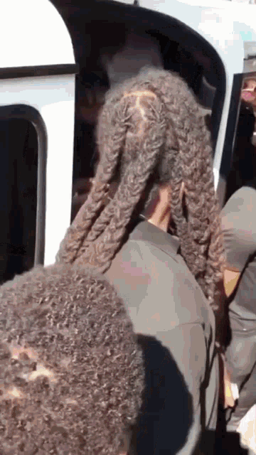 a man with dreadlocks is getting out of a white van