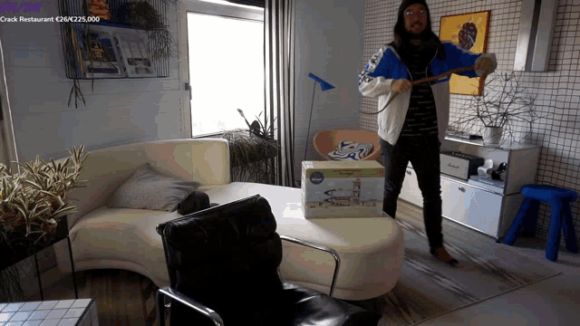 a man in a blue and white adidas jacket stands in a room
