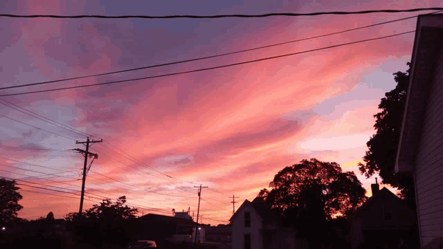 a sunset over a residential area with a few houses in the foreground