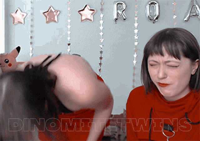 two women standing next to each other with the word dinomite twins in the upper left corner